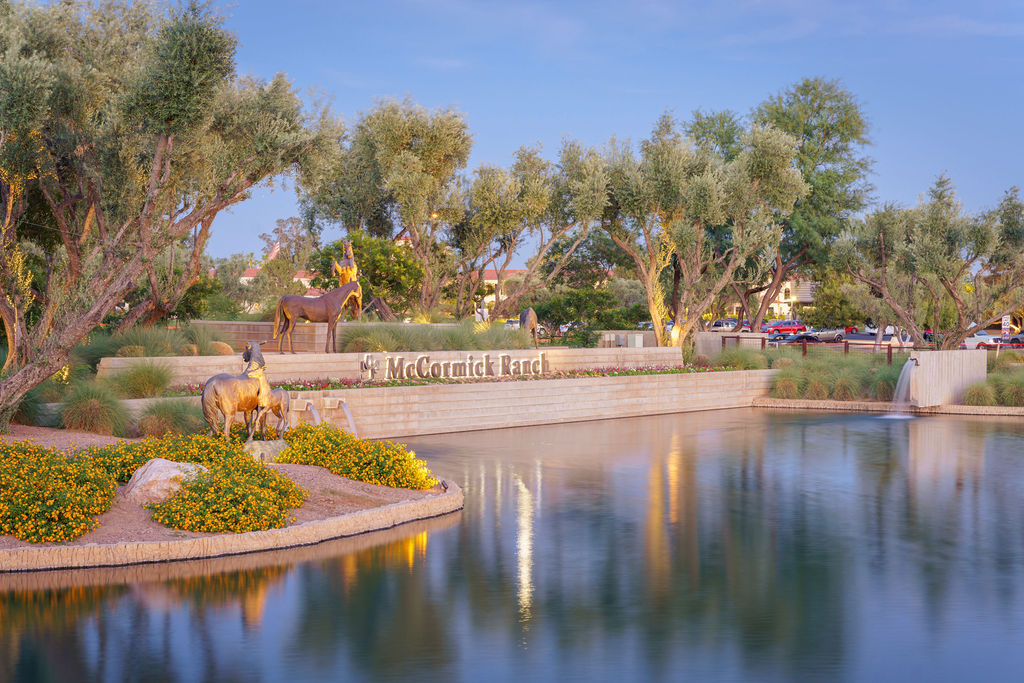 McCormick Ranch entrance with horse sculptures, flowers, trees and reflections in the water